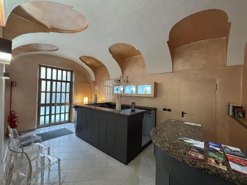 a kitchen with an island in a room with arched ceilings at DOMUS Hotel in Caselle Torinese