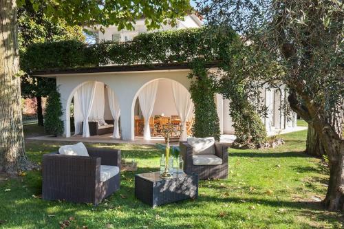a backyard with two chairs and a table in the grass at Villa Rosa del Garda Golf and Bike in Garda