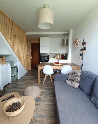 un salon avec un canapé bleu et une cuisine dans l'établissement Duplex de montagne 4 personnes, à Uvernet