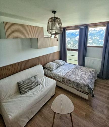 un salon avec un lit et un canapé dans l'établissement Duplex de montagne 4 personnes, à Uvernet