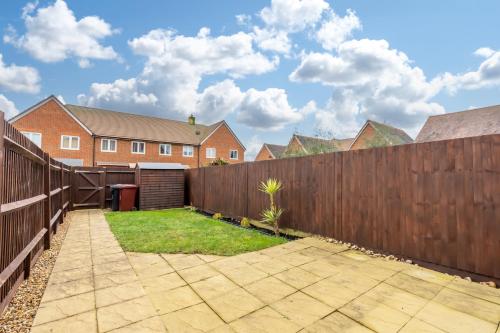 a backyard with a wooden fence and a yard at Rolls Royce View - 2 Bed House Sleeps 6 near Goodwood, Witterings and Rolls Royce Factory in Chichester