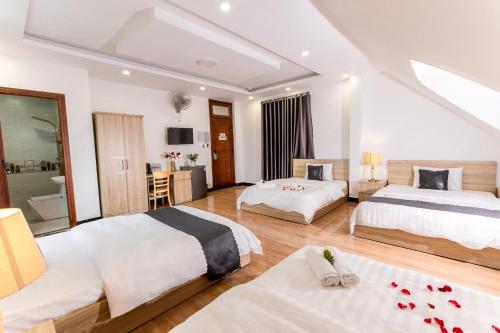 a hotel room with two beds and a bathroom at Hawaii Hotel Dalat in Da Lat