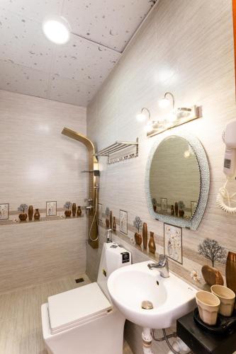 a bathroom with a sink and a toilet and a mirror at Hawaii Hotel Dalat in Da Lat