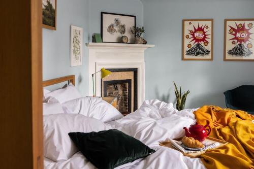 a bedroom with a bed with white sheets and a fireplace at North Lodge & River Cabin in Banchory