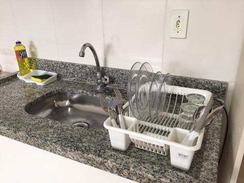 a kitchen sink with a dish drying rack next to it at Pousada Dubai in Taubaté