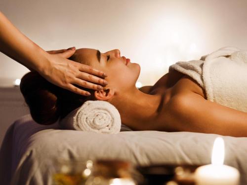 a woman laying on a bed getting a massage at Sofitel Brussels Europe in Brussels
