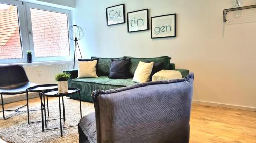 a living room with a green couch and a table at Top Wohnung in Göttingen in Göttingen