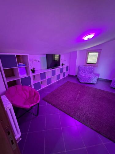 a purple room with a couch and a tv at Casa dello Yoga Suite e Private Spa in Colonnella