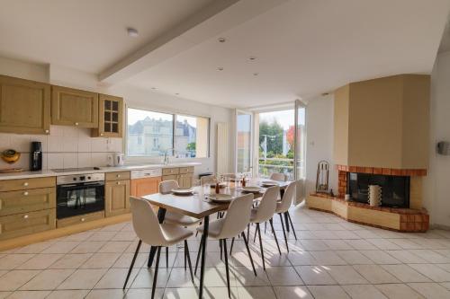 une cuisine avec une table et des chaises dans une pièce dans l'établissement Côté Océan - Appt vue mer de 134 m2, à Saint-Nazaire
