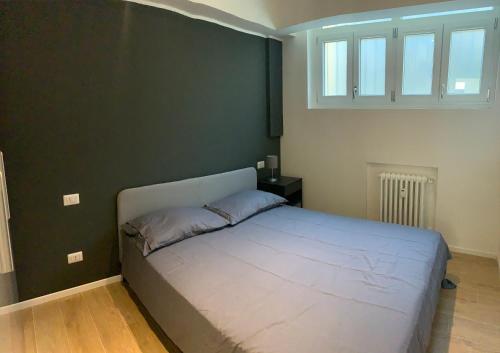 1 cama en un dormitorio con una pared verde en Home sweet home san siro, en Milán
