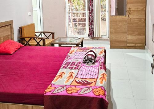 a bedroom with a bed with a pink blanket at AYM Yoga Resort Arambol GOA in Arambol