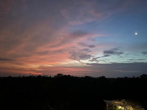 a cloudy sky with a sunset in the background at Brata Cottage Ubud in Ubud