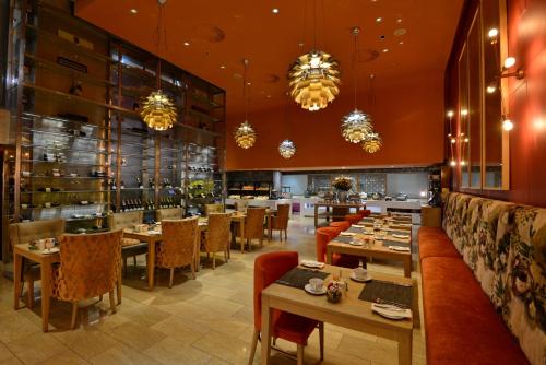 a restaurant with tables and chairs and chandeliers at Taj Cape Town in Cape Town