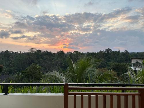 a sunset from the balcony of a house at Brata Cottage Ubud in Ubud