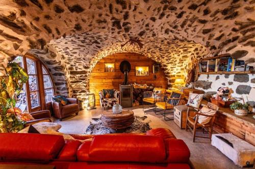 un grand salon avec un mur en pierre dans l'établissement Le refuge des Toupins, à Prunières