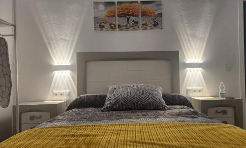 a bedroom with a bed with two lights on it at Apartamentos Rey 2 in Prado del Rey
