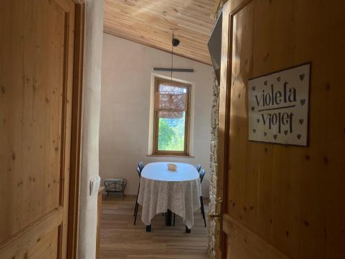a dining room with a table and a window at Can Banal - Camping y Masia Rural in Montagut