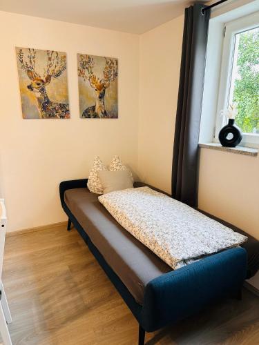 a bed in a room with three paintings on the wall at FeWo zum Heuweg in Hofkirchen