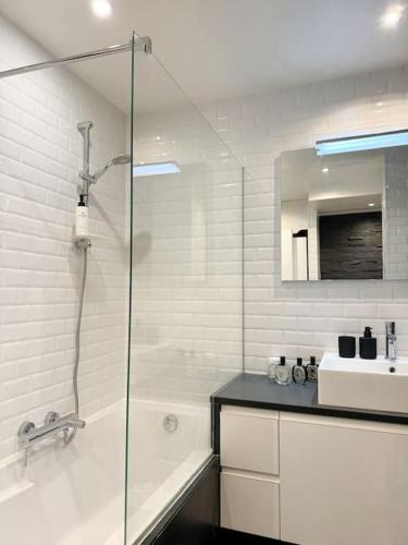 une salle de bain avec une douche, une baignoire et un lavabo dans l'établissement Appartement cosy au centre-ville, à Strasbourg