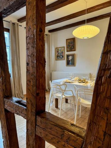 une salle à manger avec une table et des chaises blanches dans l'établissement Appartement cosy au centre-ville, à Strasbourg