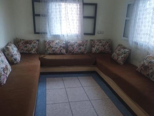 a couch in a living room with a window at Tildi surf house in Imsouane