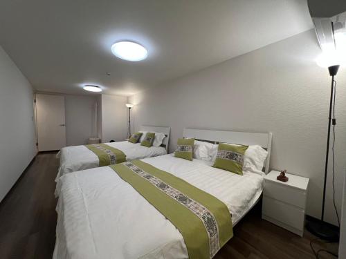 two beds in a small room with two lights at 环球影城附近安静独栋简约新风民宿 in Osaka