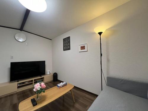a living room with a couch and a television at 环球影城附近安静独栋简约新风民宿 in Osaka