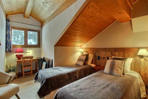 a bedroom with two beds in a room at ARC 1950 - Appartement 8 personnes Duplex Cheminée - ski aux pieds - Sauna, Hammam, Jacuzzi, Piscine in Arc 1950