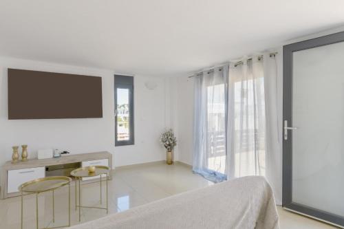 a white room with a flat screen tv and a bed at Martas Dream - Near Beach Apartments in Daratso
