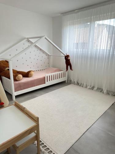 - une chambre pour enfants avec un lit bébé avec un ours en peluche suspendu à la fenêtre dans l'établissement Maison proche marché de Noel, à Wintzenheim