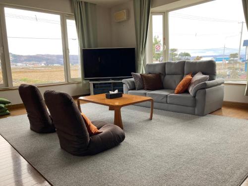 un soggiorno con un divano, sedie e un tavolo di countryside FURANO a Nakafurano