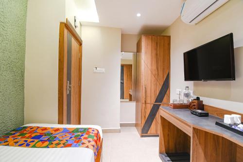 a hotel room with a bed and a television at FabHotel Prime Swagatam International Chinar Park in Kolkata