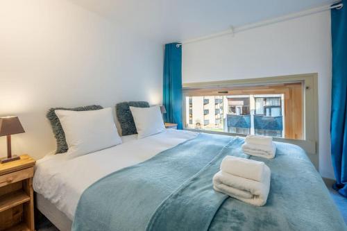 une chambre avec un grand lit avec des serviettes dessus dans l'établissement Ancolie - Beautiful apartment 6-people close to ski lifts - By Cozee Rentals, à Chamonix-Mont-Blanc