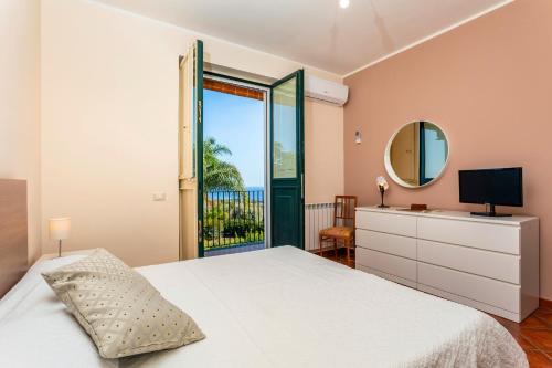 a bedroom with a bed and a mirror at Villa Vittoria - Santa Tecla in Acireale