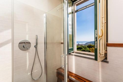 a bathroom with a shower with a window at Villa Vittoria - Santa Tecla in Acireale