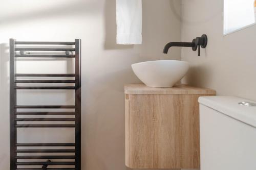 a bathroom with a white bowl on a counter next to a sink at Calm Cosy House with Beautiful Riverside Walk to Centre in York