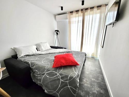 une chambre avec un lit avec un oreiller rouge dessus dans l'établissement Centre ville - Métro B - Parking sup, à Toulouse