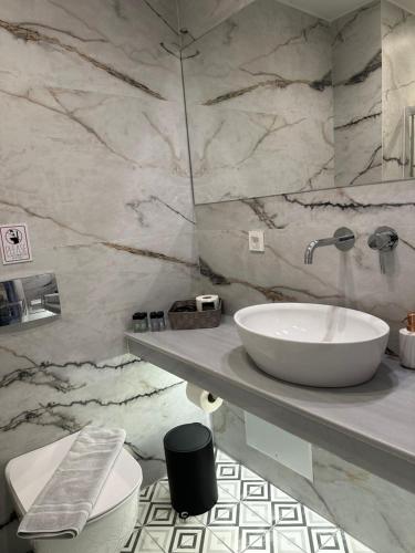 a marble bathroom with a sink and a toilet at Belle Athenes - Luxury Rooms at Monastiraki Railway Station in Athens