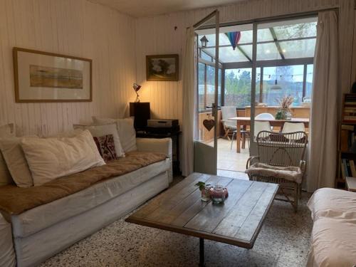 un salon avec un canapé et une table basse dans l'établissement Maison de village, à Rémalard