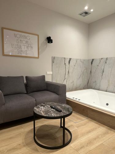 a living room with a couch and a bath tub at Belle Athenes - Luxury Rooms at Monastiraki Railway Station in Athens