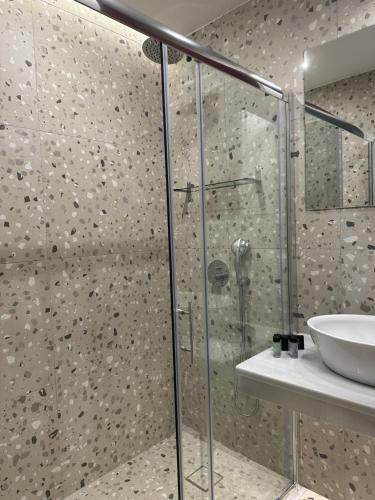 a bathroom with a glass shower and a sink at Belle Athenes - Luxury Rooms at Monastiraki Railway Station in Athens