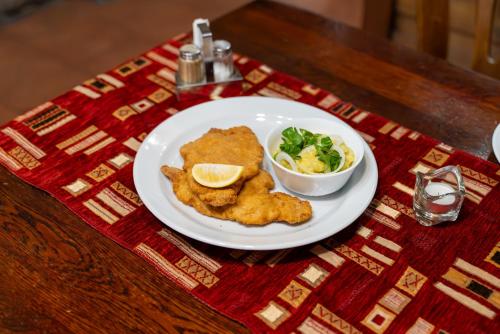 a plate of food with chicken and salad on a table at Hotel Rustikal Hustopeče - U Mandloňových sadů in Hustopeče
