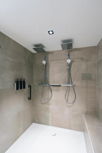 La salle de bains est pourvue d'une douche avec deux pommeaux de douche. dans l'établissement Residence Inn by Marriott Strasbourg, à Strasbourg