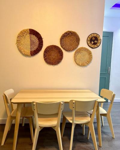 a table and chairs with umbrellas on the wall at Behomu Apartments Kampala in Kira
