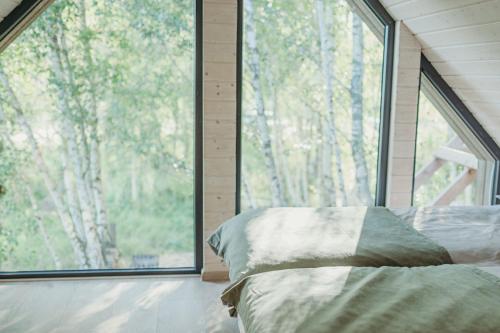 a bedroom with a bed in front of a large window at Zatoka Bielika Glamping in Sielsko