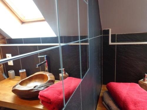 a bathroom with a toilet with red towels and a window at La Boucle de l'Adour Chambres d'Hôtes in Campan