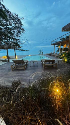 a group of picnic tables on the beach at night at Cape Beach Villa Samui in Ban Bang Po