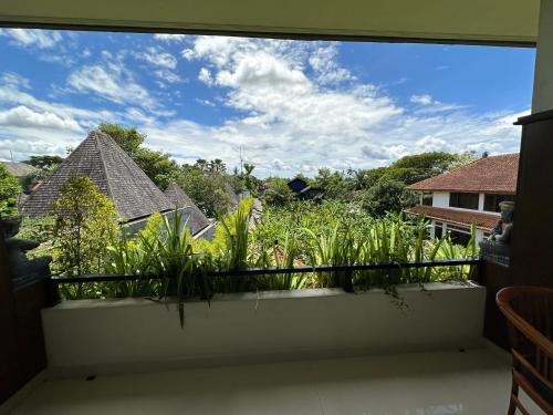 a window view of a garden from a balcony at Brata Cottage Ubud in Ubud