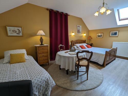 une chambre avec deux lits et une table et des chaises dans l'établissement Chambres d'hôtes restauration XVIIIe avec WiFi, au cœur des Châteaux de la Loire - FR-1-590-331, à Tavers
