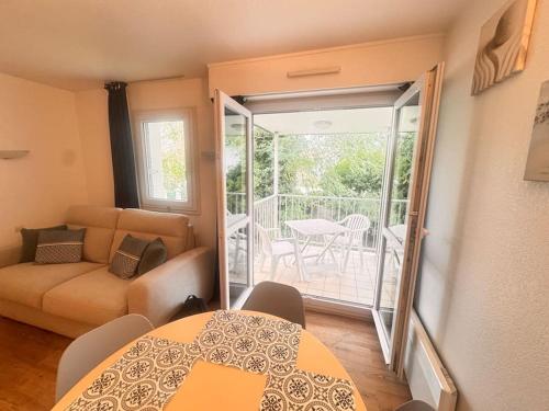 d'un salon avec une table et un canapé ainsi que d'un balcon. dans l'établissement Studio idyllique et cosy à La Baule - Plage à pied, à La Baule